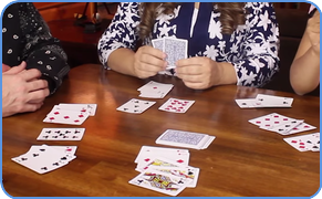 Family playing rummy card game in home